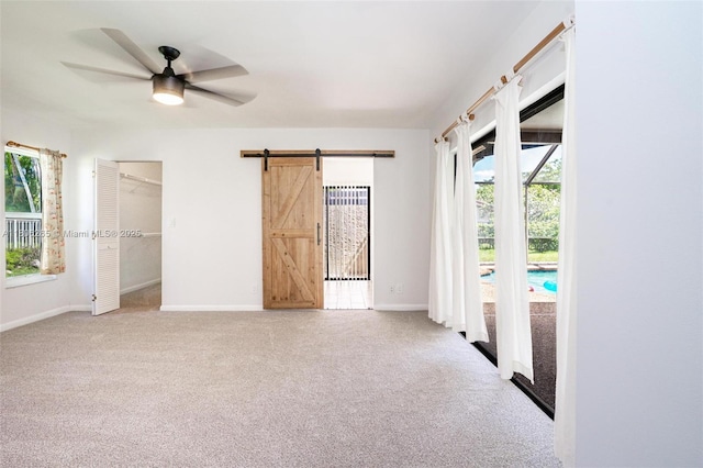 9919 SW 1st Ct, Coral Springs, FL 33071 - carpeted empty room featuring a barn door, healthy amount of natural light, ceiling fan, and baseboards