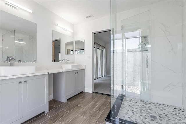 9919 SW 1st Ct, Coral Springs, FL 33071 - bathroom featuring a marble finish shower, double vanity, wood finish floors, and baseboards