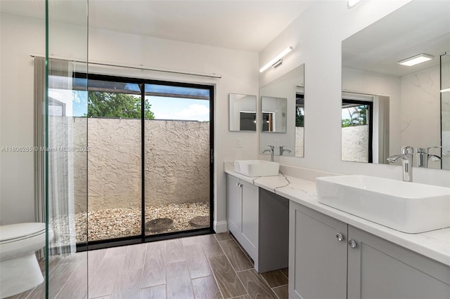 9919 SW 1st Ct, Coral Springs, FL 33071 - full bathroom with healthy amount of natural light, toilet, double vanity, and wood tiled floors