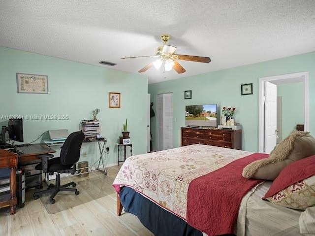 15824 Cotswold Ct, Davie, FL 33331 - bedroom with light wood-style floors, a desk, a textured ceiling, a ceiling fan, and a closet