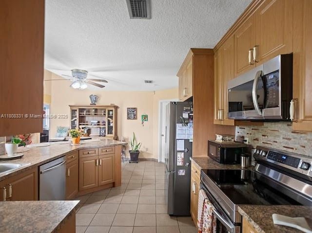 15824 Cotswold Ct, Davie, FL 33331 - kitchen with stainless steel appliances, a ceiling fan, light tile patterned floors, decorative backsplash, and stone counters
