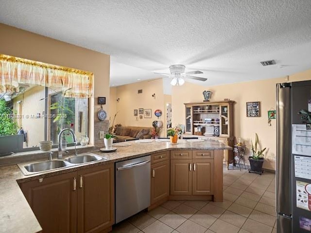 15824 Cotswold Ct, Davie, FL 33331 - kitchen with stainless steel appliances, a sink, ceiling fan, light tile patterned floors, and a peninsula