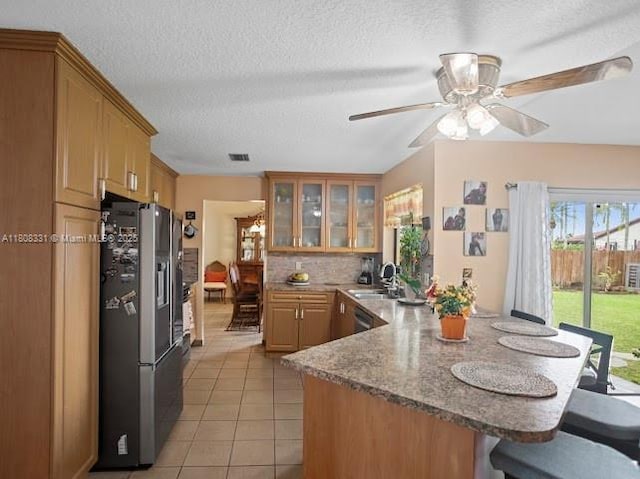 15824 Cotswold Ct, Davie, FL 33331 - kitchen with stainless steel refrigerator with ice dispenser, a peninsula, a breakfast bar, a sink, and light tile patterned floors