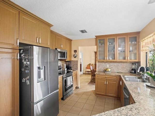 15824 Cotswold Ct, Davie, FL 33331 - kitchen with appliances with stainless steel finishes, a sink, light tile patterned flooring, backsplash, and glass insert cabinets