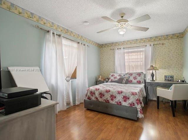 15824 Cotswold Ct, Davie, FL 33331 - bedroom with wallpapered walls, a textured ceiling, wood finished floors, and ceiling fan