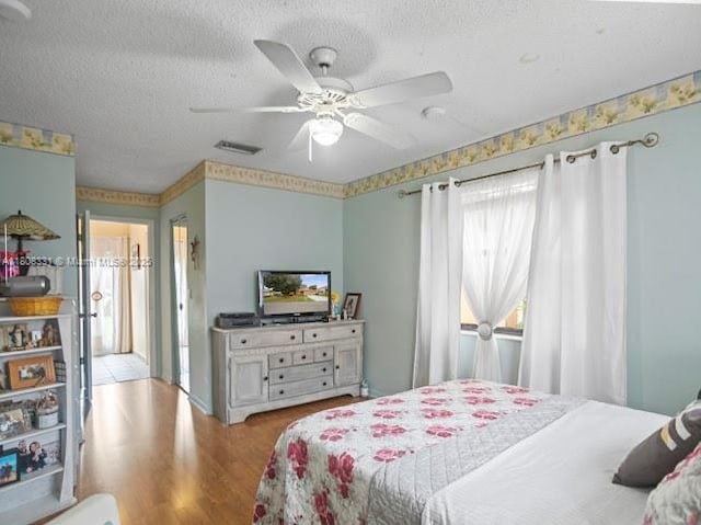 15824 Cotswold Ct, Davie, FL 33331 - bedroom featuring a textured ceiling, wood finished floors, and ceiling fan