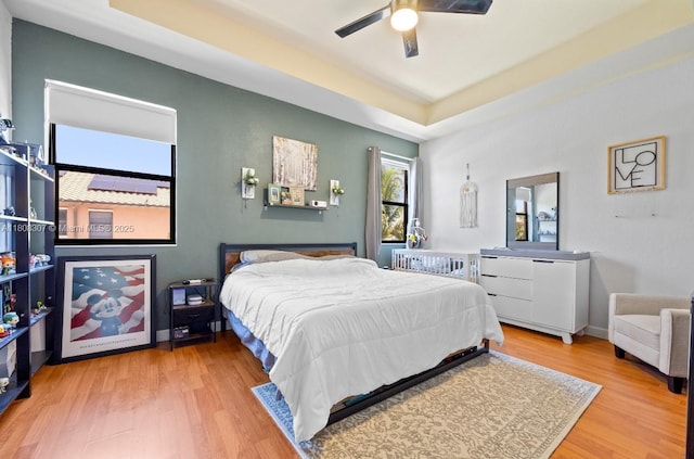 3427 W 89th Ter, Hialeah, FL 33018 - bedroom featuring wood finished floors, a tray ceiling, and ceiling fan