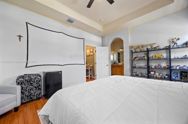 3427 W 89th Ter, Hialeah, FL 33018 - bedroom with arched walkways, wood finished floors, a ceiling fan, and ensuite bath