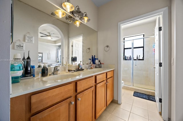 3427 W 89th Ter, Hialeah, FL 33018 - bathroom featuring a ceiling fan, toilet, double vanity, a stall shower, and tile patterned flooring