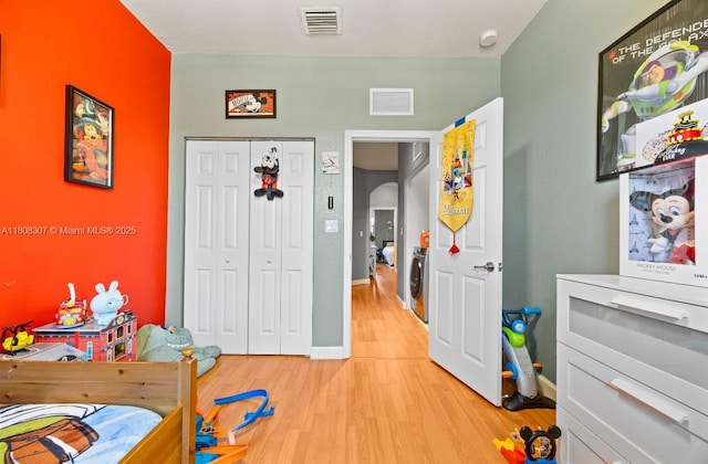 3427 W 89th Ter, Hialeah, FL 33018 - bedroom with light wood finished floors, washer / dryer, a closet, baseboards, and arched walkways