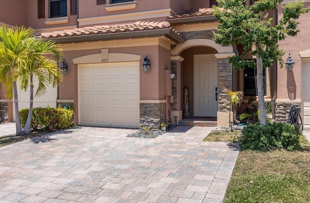 3427 W 89th Ter, Hialeah, FL 33018 - entrance to property featuring stone siding, a garage, stucco siding, and a tiled roof