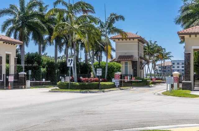 3427 W 89th Ter, Hialeah, FL 33018 - view of asphalt street with traffic signs, a gate, curbs, and a gated entry