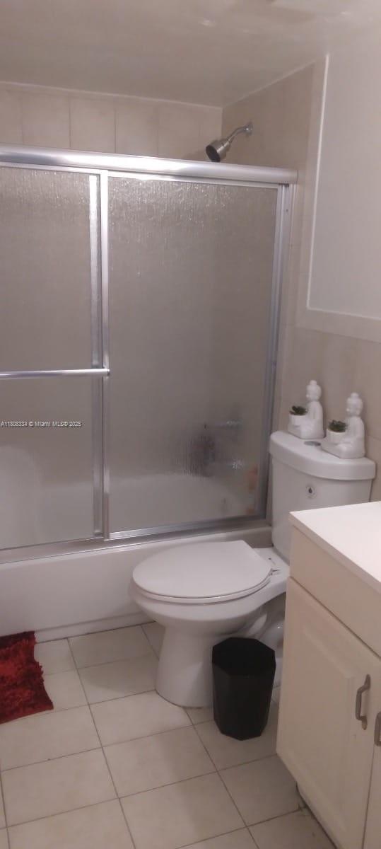 650 NE 149th St Unit 407A, Miami, FL 33161 - bathroom with toilet, tile patterned floors, and enclosed tub / shower combo