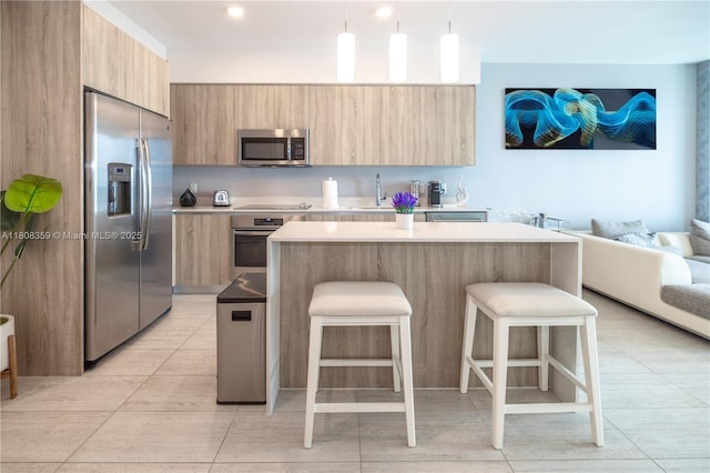 3900 Biscayne Blvd Unit S-1118, Miami, FL 33137 - kitchen with appliances with stainless steel finishes, modern cabinets, light brown cabinets, a breakfast bar, and light countertops