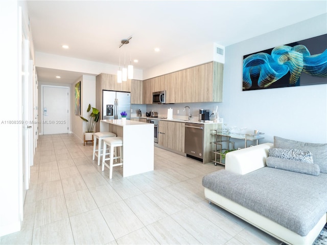 3900 Biscayne Blvd Unit S-1118, Miami, FL 33137 - kitchen featuring appliances with stainless steel finishes, modern cabinets, a sink, a breakfast bar area, and light countertops