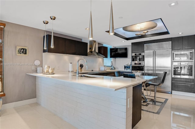 17001 Collins Ave Unit 2501, Sunny Isles Beach, FL 33160 - kitchen featuring built in appliances, wall chimney range hood, a breakfast bar area, and modern cabinets