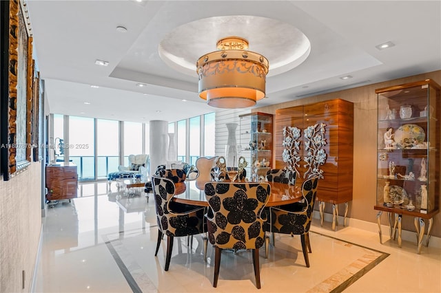17001 Collins Ave Unit 2501, Sunny Isles Beach, FL 33160 - dining area with inlaid floor details, a tray ceiling, recessed lighting, expansive windows, and marble tiled floors