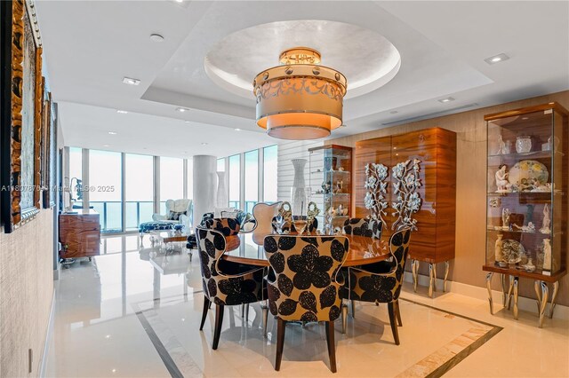 17001 Collins Ave Unit 2501, Sunny Isles Beach, FL 33160 - dining area with inlaid floor details, a tray ceiling, recessed lighting, expansive windows, and marble tiled floors