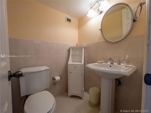 8233 Harding Ave Unit 204, Miami Beach, FL 33141 - half bathroom featuring tile walls, toilet, tile patterned flooring, and wainscoting