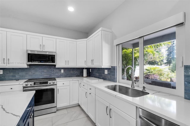 9192 Picot Ct, Boynton Beach, FL 33472 - kitchen with stainless steel appliances, a sink, white cabinetry, backsplash, and recessed lighting