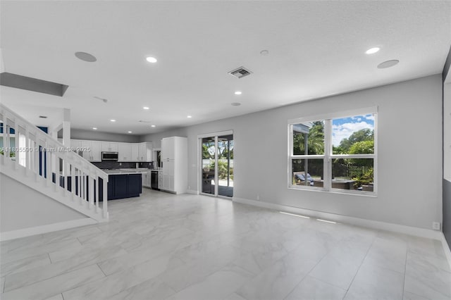 9192 Picot Ct, Boynton Beach, FL 33472 - unfurnished living room featuring baseboards, recessed lighting, light marble finish floors, and stairway