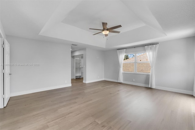 9192 Picot Ct, Boynton Beach, FL 33472 - spare room with a tray ceiling, a ceiling fan, light wood finished floors, and baseboards