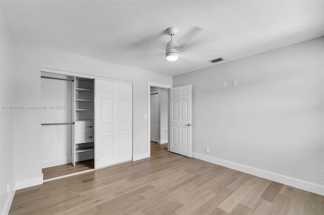 9192 Picot Ct, Boynton Beach, FL 33472 - unfurnished bedroom featuring baseboards, light wood-style floors, a closet, a textured ceiling, and a ceiling fan