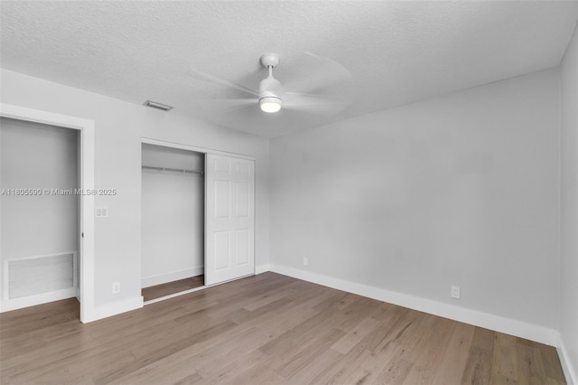 9192 Picot Ct, Boynton Beach, FL 33472 - unfurnished bedroom featuring a closet, baseboards, wood finished floors, ceiling fan, and a textured ceiling