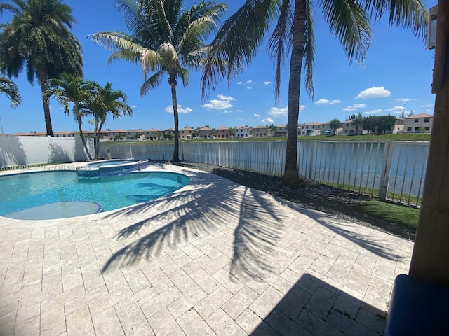3406 W 88th St, Hialeah, FL 33018 - view of swimming pool with a water view, a patio, a fenced backyard, a pool with connected hot tub, and a residential view