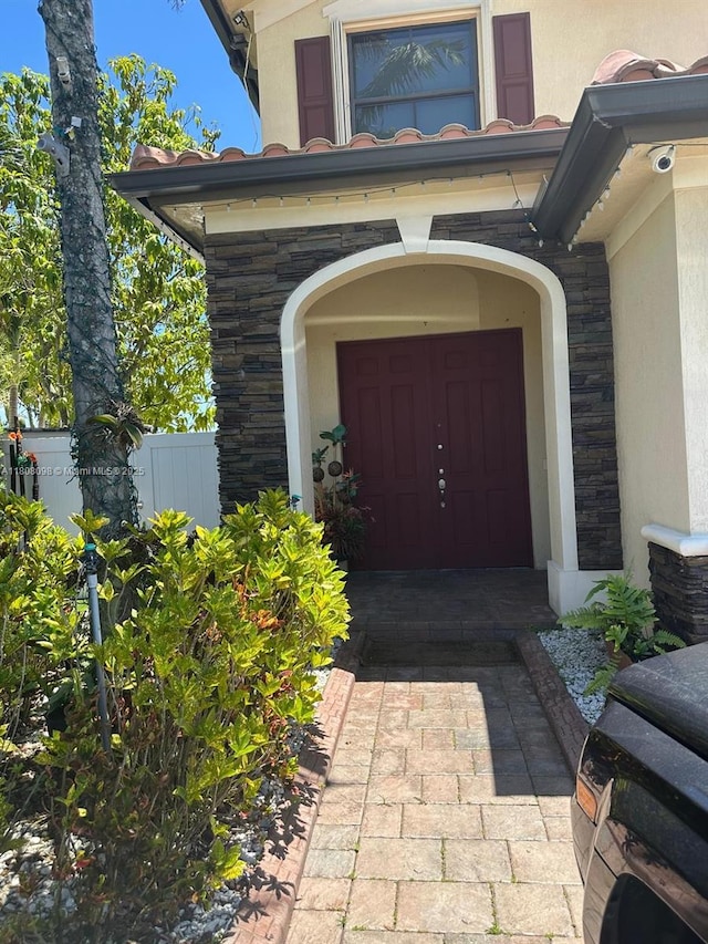 3406 W 88th St, Hialeah, FL 33018 - property entrance featuring stone siding, stucco siding, and a security system
