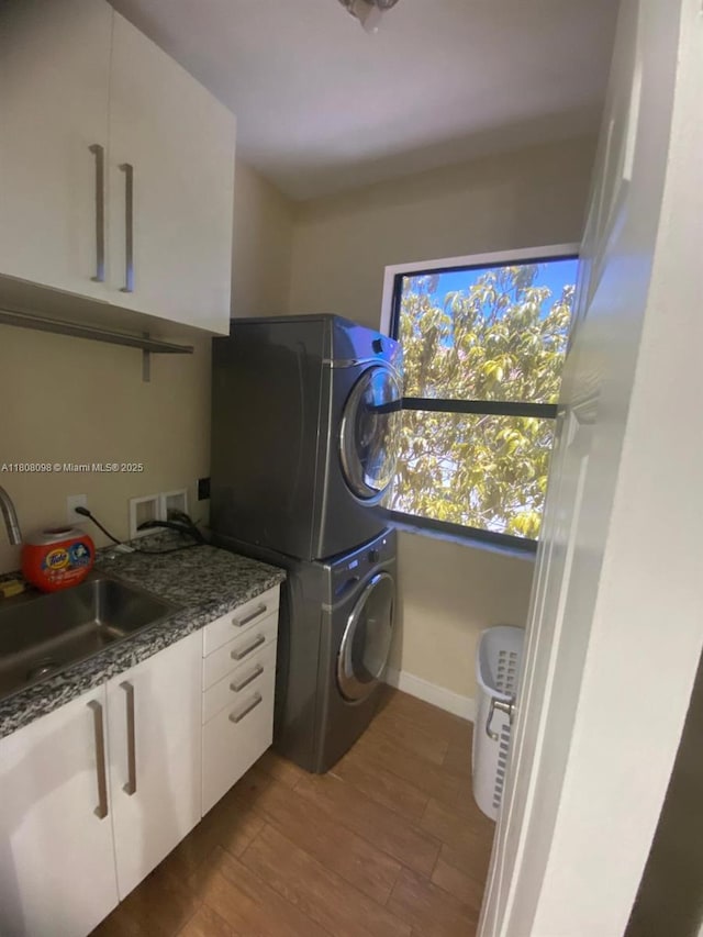 3406 W 88th St, Hialeah, FL 33018 - washroom featuring estacked washer and dryer, cabinet space, dark wood-style flooring, and baseboards
