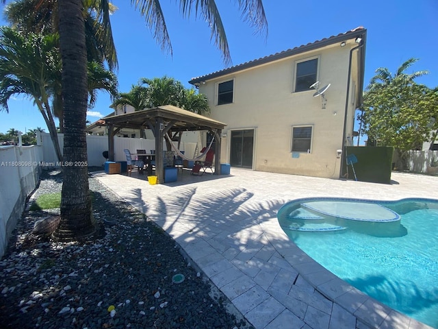 3406 W 88th St, Hialeah, FL 33018 - rear view of property featuring a gazebo, a fenced backyard, a patio, stucco siding, and a tile roof