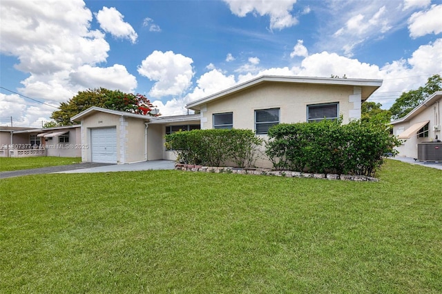 2240 NW 47th Ter, Lauderhill, FL 33313 - view of front of home featuring central AC, a garage, stucco siding, and a front lawn