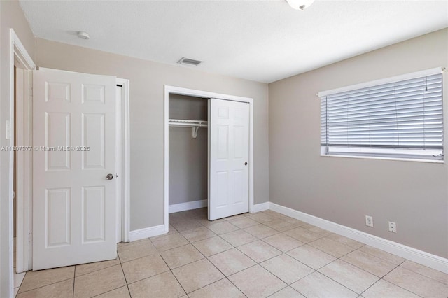2240 NW 47th Ter, Lauderhill, FL 33313 - unfurnished bedroom featuring a closet, light tile patterned floors, and baseboards