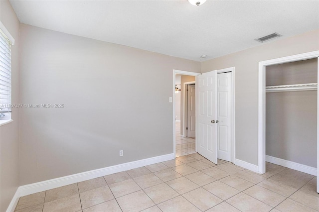 2240 NW 47th Ter, Lauderhill, FL 33313 - unfurnished bedroom featuring baseboards, light tile patterned flooring, and multiple closets
