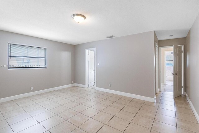 2240 NW 47th Ter, Lauderhill, FL 33313 - spare room with healthy amount of natural light, light tile patterned flooring, and baseboards