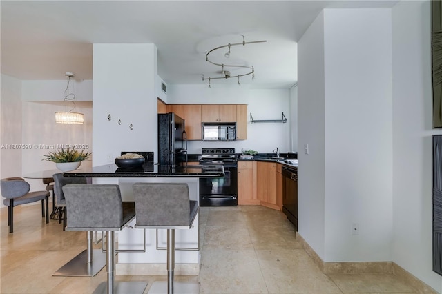 1330 W Ave Unit 902, Miami Beach, FL 33139 - kitchen featuring black appliances, dark countertops, a sink, light brown cabinetry, and decorative light fixtures