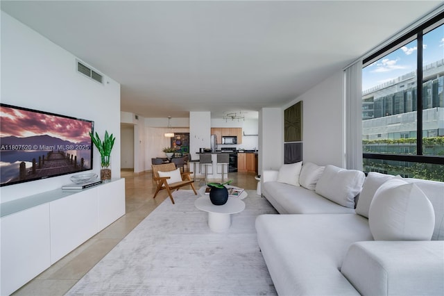 1330 W Ave Unit 902, Miami Beach, FL 33139 - living room featuring healthy amount of natural light, light tile patterned floors, and a wall of windows