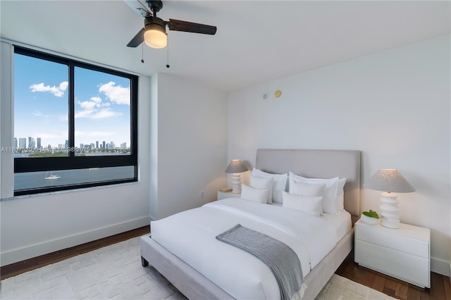 1330 W Ave Unit 902, Miami Beach, FL 33139 - bedroom with wood finished floors, baseboards, a skyline view, and a ceiling fan