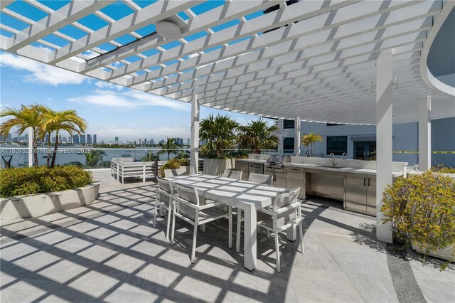 1330 W Ave Unit 902, Miami Beach, FL 33139 - view of patio featuring outdoor dining space, exterior kitchen, a sink, and a pergola