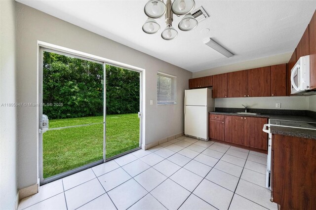 6871 SW 18th St, North Lauderdale, FL 33068 - kitchen with white appliances, dark countertops, a sink, a chandelier, and light tile patterned floors