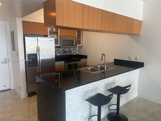 1750 N Bayshore Dr Unit 1410, Miami, FL 33132 - kitchen featuring stainless steel appliances, a sink, light tile patterned floors, and brown cabinetry