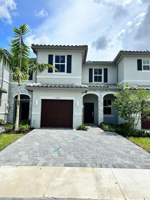 11965 NW 47th Mnr, Coral Springs, FL 33076 - multi unit property featuring decorative driveway, stucco siding, an attached garage, a tiled roof, and stone siding