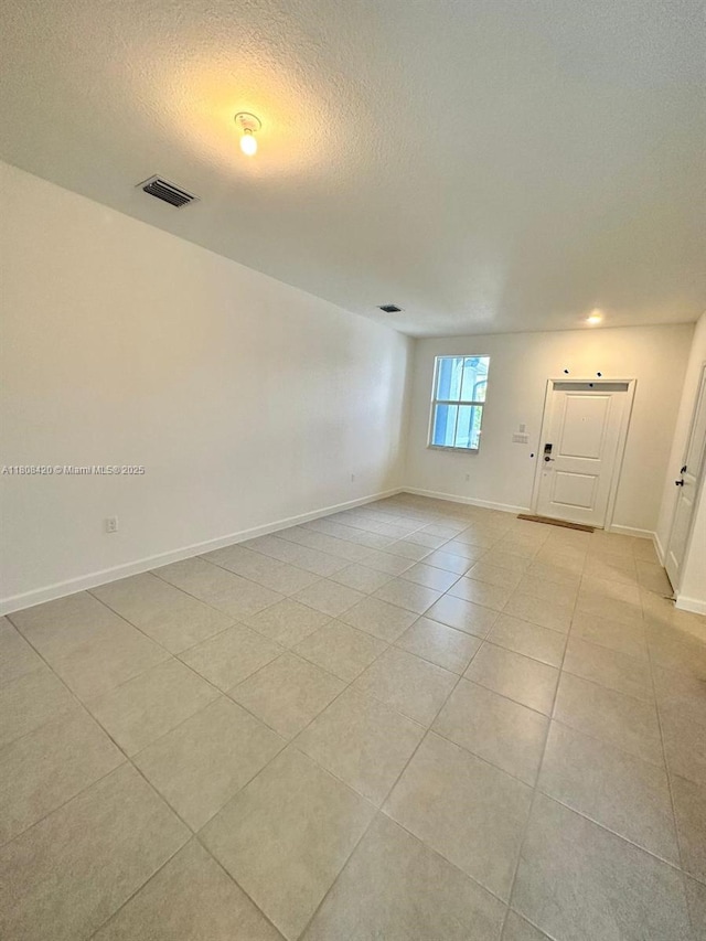 11965 NW 47th Mnr, Coral Springs, FL 33076 - spare room with a textured ceiling, light tile patterned flooring, and baseboards