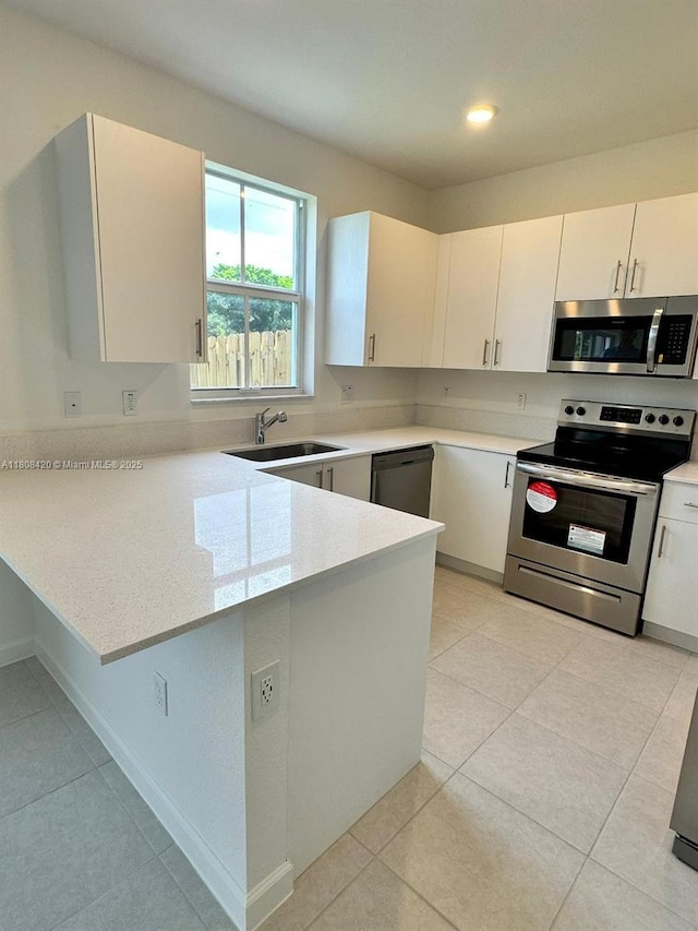 11965 NW 47th Mnr, Coral Springs, FL 33076 - kitchen with appliances with stainless steel finishes, a sink, a peninsula, light countertops, and recessed lighting