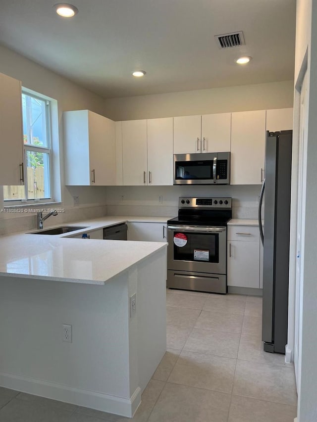 11965 NW 47th Mnr, Coral Springs, FL 33076 - kitchen featuring stainless steel appliances, a sink, a peninsula, white cabinets, and recessed lighting