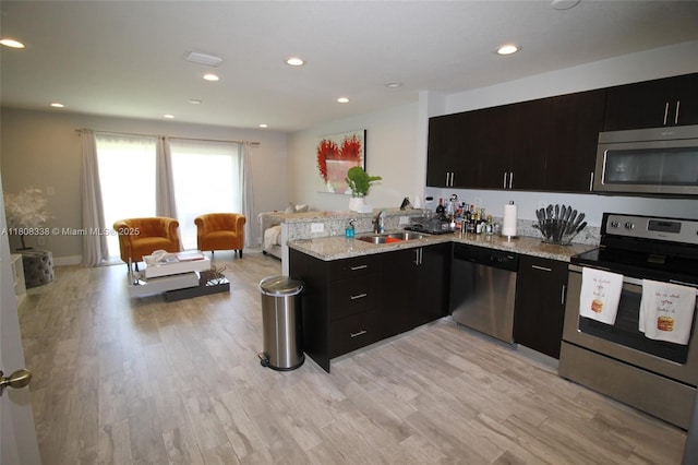 3045 SW 129th Way Unit 152, Miramar, FL 33027 - kitchen with appliances with stainless steel finishes, a sink, dark cabinets, a peninsula, and light wood-style floors