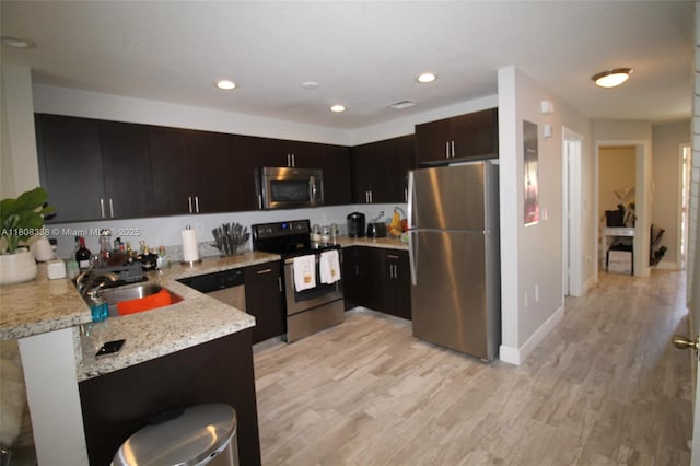 3045 SW 129th Way Unit 152, Miramar, FL 33027 - kitchen featuring appliances with stainless steel finishes, a sink, light wood-style floors, a peninsula, and recessed lighting