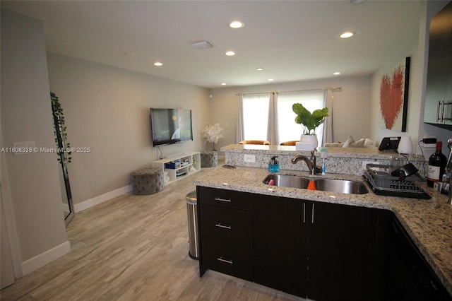 3045 SW 129th Way Unit 152, Miramar, FL 33027 - kitchen featuring a sink, dark cabinetry, light wood finished floors, light stone counters, and open floor plan