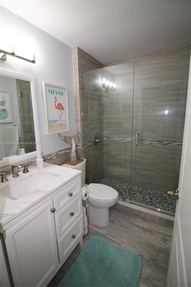 3045 SW 129th Way Unit 152, Miramar, FL 33027 - full bathroom with vanity, toilet, a textured ceiling, and a stall shower